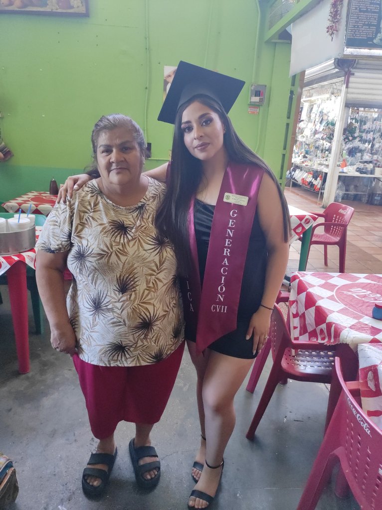 Joven celebra su graduación en el mercado donde trabajan sus padres