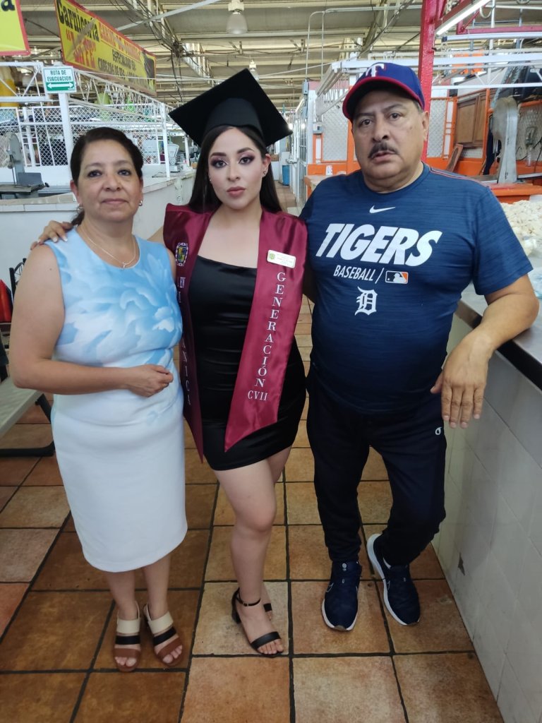 Joven celebra su graduación en el mercado donde trabajan sus padres